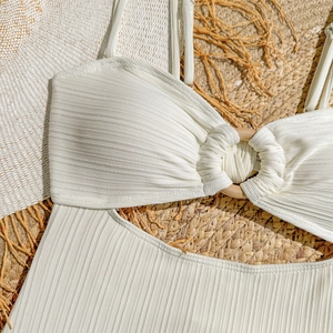 Gros plan du maillot de bain blanc plissé avec un anneau décoratif en bois naturel