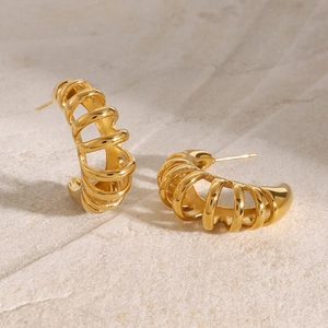 Detailed close-up of 18k gold-plated stainless steel hollow earrings on a stone surface