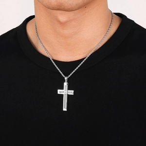 Gros plan du pendentif croix en acier inoxydable hip hop porté par un mannequin masculin