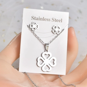 Macro detail of stainless steel clover jewelry set with four heart-shaped silver petals
