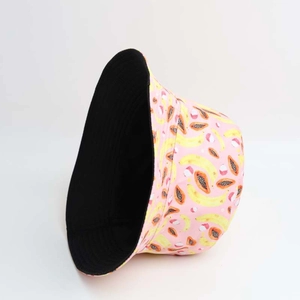 Detail of reversible bucket hat showing pink tropical fruit print and solid black side