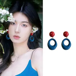 Detail view of heart-shaped crystal tassel earrings with a vibrant contrast finish