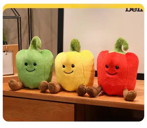 Close-up of cute plush colorful peppers with embroidered faces on a wooden desk