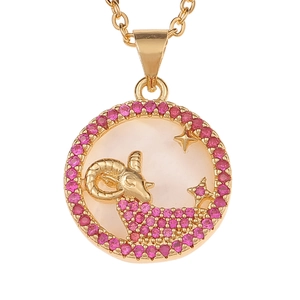 Macro shot of gold Aries pendant with pink zircon inlays and white shell base