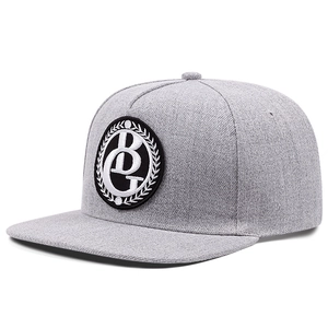 Close-up of grey snapback cap with detailed BG circular embroidery and twill texture