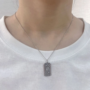 Silver tarot sun star rectangular pendant necklace worn on a white t-shirt