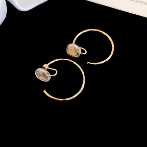 Gros plan détaillé de boucles d'oreilles clips dorées en C avec coussinets en silicone doux
