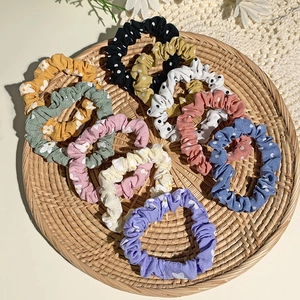 Detail of fabric scrunchies with daisy floral patterns and vintage polka dots in a basket