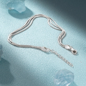 Macro detail of silver S925 sterling silver triple layer snake chain with lobster clasp