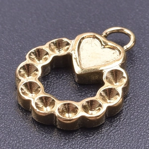 Macro shot of 18k gold heart charm with hollow center and circular groove detail