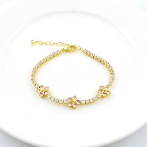 Golden flower bracelet with colorful zircons and adjustable lobster clasp on white tray