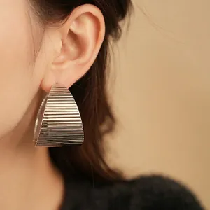 Modern oversized geometric earrings with ribbed texture in a minimalist metallic finish