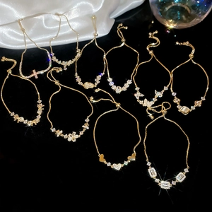 Detail view of gold-plated adjustable bracelets with zircon charms and drawstring closure