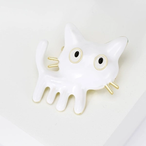 Close-up of white enamel cartoon cat brooch with gold plating and long-legged design