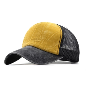 Detail of vintage washed canvas trucker hat featuring yellow front and black mesh back