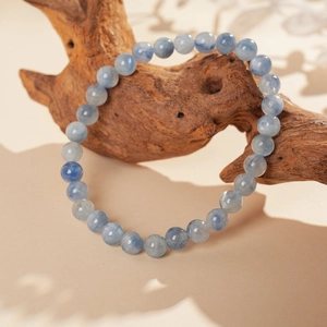 Detailed view of kyanite beaded bracelet with silk luster on natural wood prop