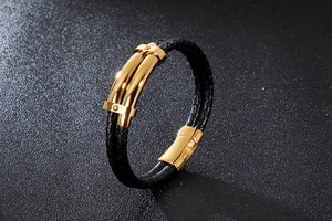 Détail macro du bracelet en cuir tressé noir avec boucle en acier inoxydable poli doré