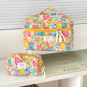 Detailed view of quilted makeup bags with colorful graffiti prints on a white shelf