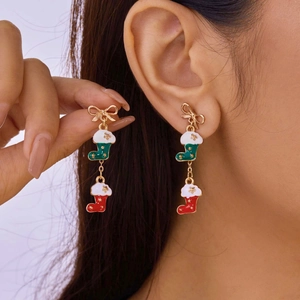 Close-up of Christmas bow earrings with red and green holiday stockings on ear