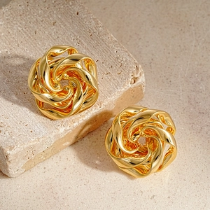 Elegant gold spiral floral earrings on textured stone background for a vintage look
