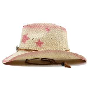 Detail of beige straw cowboy hat with pink star patterns and adjustable wind cord