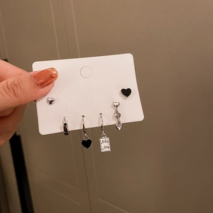 Detail of 6-piece silver heart stud earrings set with black enamel accents on display card