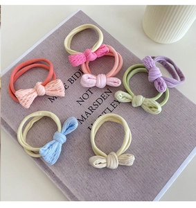 Detailed close-up of six pastel ribbed bow hair ties arranged on an open book