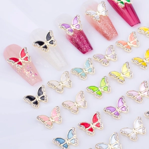 Detailed macro shot of colorful enamel butterfly nail charms with inlaid rhinestones