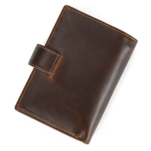Macro view of dark brown genuine leather texture with contrast stitching and buckle closure