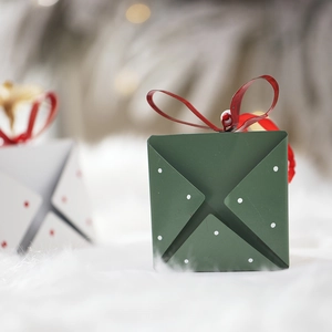 Nordic style metal Christmas ornaments in dark green and red on white fur background