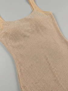 Détail de la robe en maille chair montrant les strass brillants et le col en U