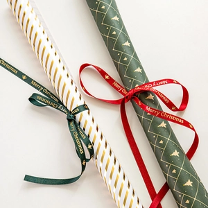 Christmas wrapping paper rolls with gold foil trees, stripes and Merry Christmas ribbons