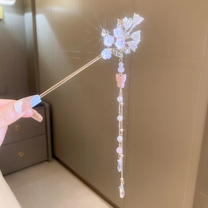 Détail de l'épingle à cheveux fleur avec pendentif papillon rose et longs glands