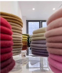 Detailed stack of colorful wool beret hats in pink wine red ginger and beige