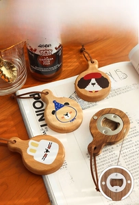 Détail de décapsuleurs magnétiques en bois avec motifs d'animaux sur table en bois