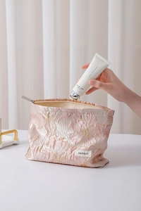 Close-up of floral jacquard makeup bag showing silk texture and high-quality metal zipper
