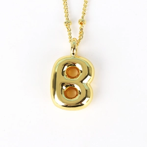 Detailed macro view of puffy letter B gold pendant with twisted rope style chain