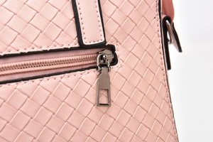 Close-up of pink woven texture and metallic zipper detail on this elegant women's bag
