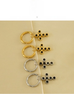 Detail of 18k gold and silver stainless steel cross hoop earrings with black gemstones