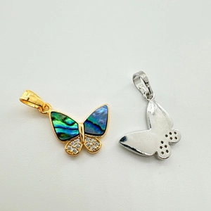 Vue macro du pendentif papillon avec nacre et zircons en finition or 18 carats et argent