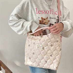 Détail du sac fourre-tout rose matelassé avec motifs d'animaux et étiquette sozakka