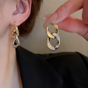 Two-tone intertwined gold and silver link hoop earrings in minimalist geometric style