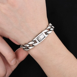 Detail of vintage embossed silver stainless steel cuban chain bracelet on male wrist