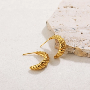 Macro shot of 18K gold plated C-shape earrings with vintage spiral textured patterns