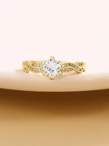 Macro shot of gold crown ring featuring a four-prong zircon setting and twisted pavé band