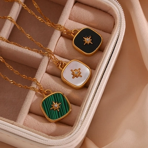 Macro detail of starburst pendants with black enamel, mother of pearl and green malachite