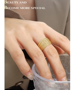 Close-up of golden multi-layered beaded ring worn on finger with elegant styling