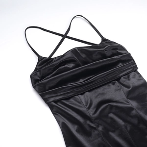 Détail d'une robe en satin noir montrant le décolleté carré plissé et les fines bretelles