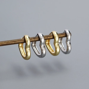 Polished S925 silver heart shaped hoop earrings in gold and silver finishes on a bar