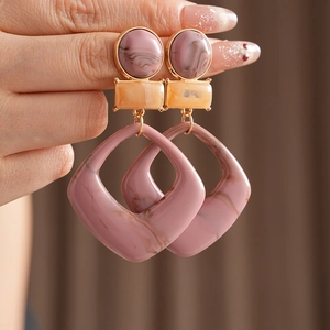 Detail showing pink and orange marble resin geometric drop earrings with gold metal links
